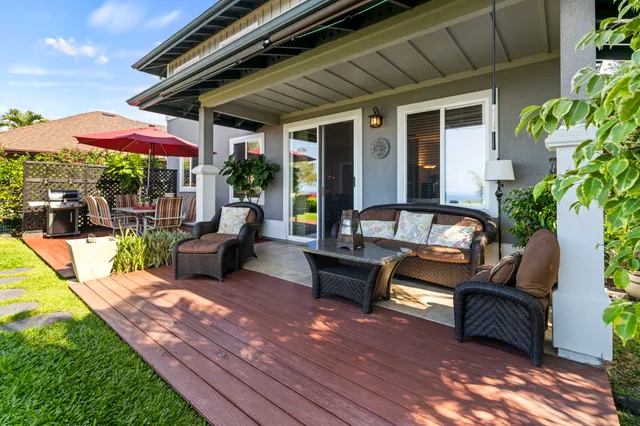 a view of a patio with couches table and chairs under an umbrella with a patio