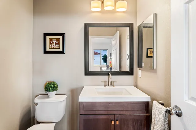 a bathroom with a sink mirror and toilet