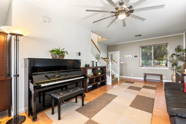 a living room with furniture and a piano