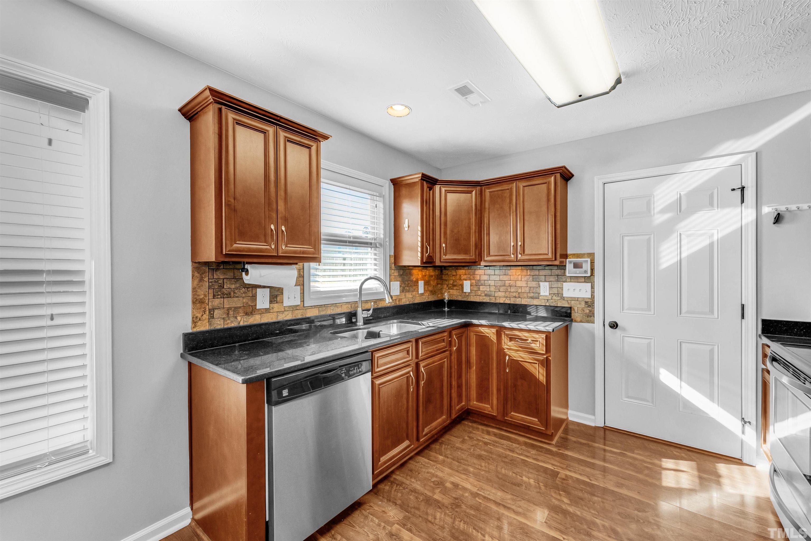 707 Botanical Court Bunnlevel, NC 28323 - Photo 11 of 31 a kitchen with stainless steel appliances granite countertop a stove a sink dishwasher a refrigerator and cabinets with wooden floor