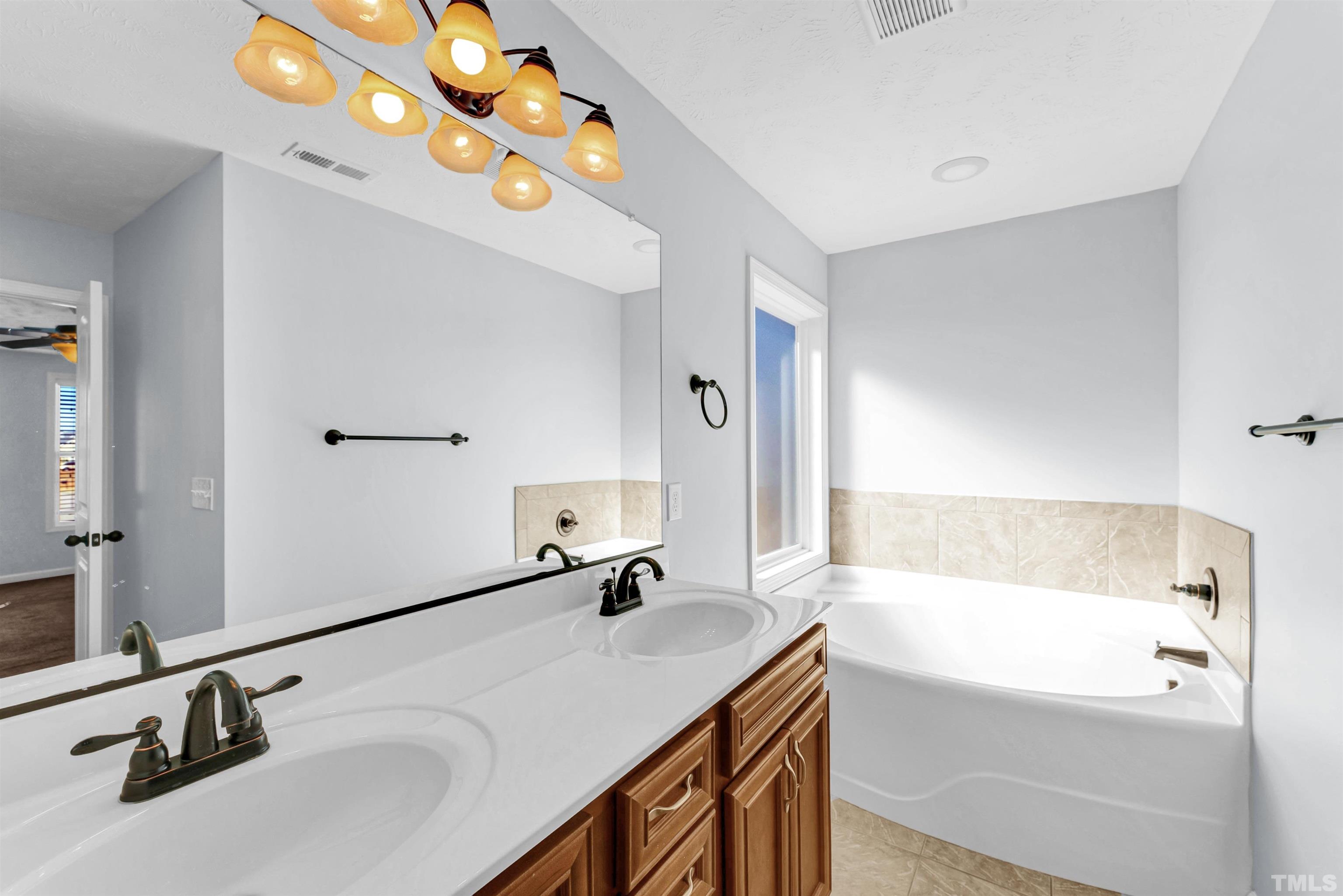 707 Botanical Court Bunnlevel, NC 28323 - Photo 15 of 31 a bathroom with a tub sink and mirror