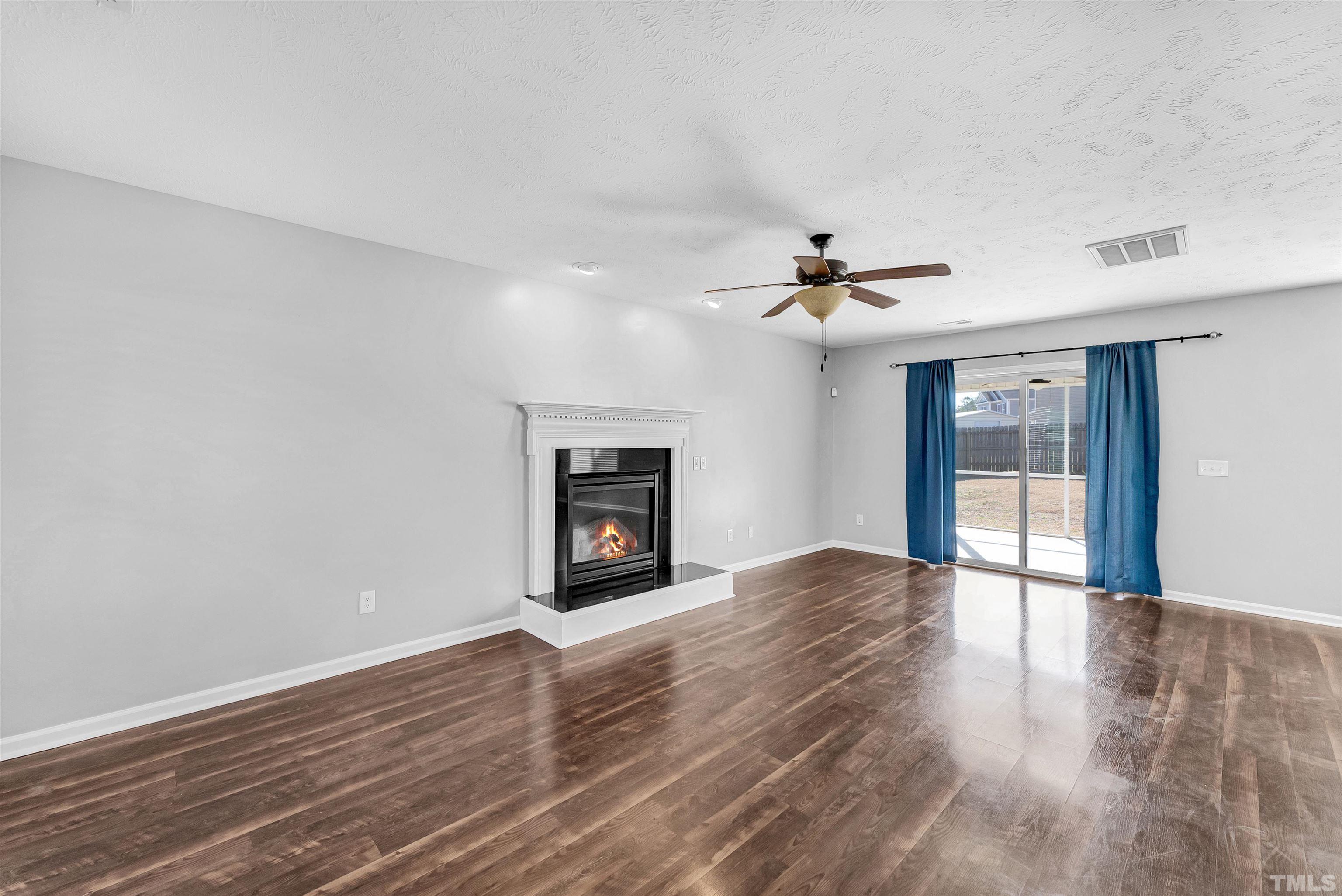 707 Botanical Court Bunnlevel, NC 28323 - Photo 5 of 31 a view of an empty room with a window and wooden floor