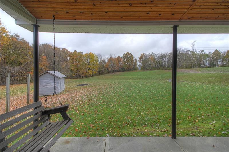 Covered back patio overlooks the land. 