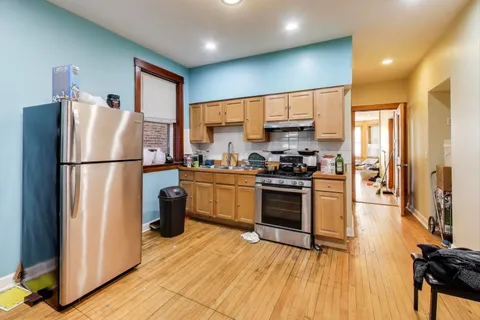 a kitchen with a refrigerator a stove top oven a sink and cabinets
