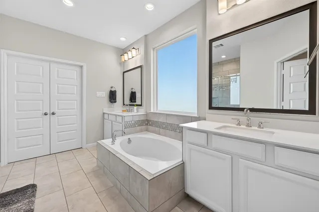 a bathroom with a tub sink and mirror