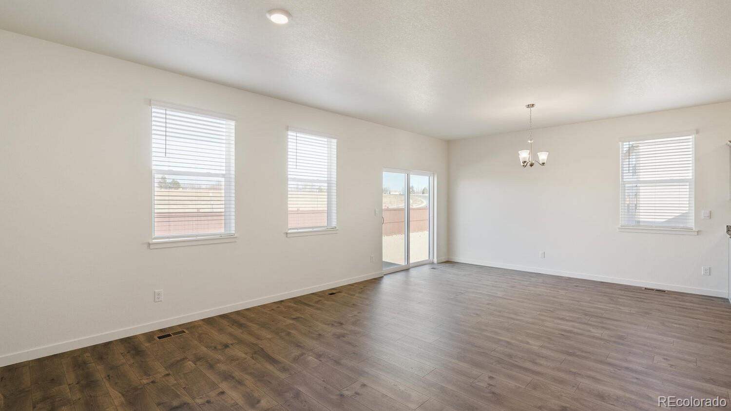950 London Way Severance, CO 80550 - Photo 10 of 21 an empty room with wooden floor and windows