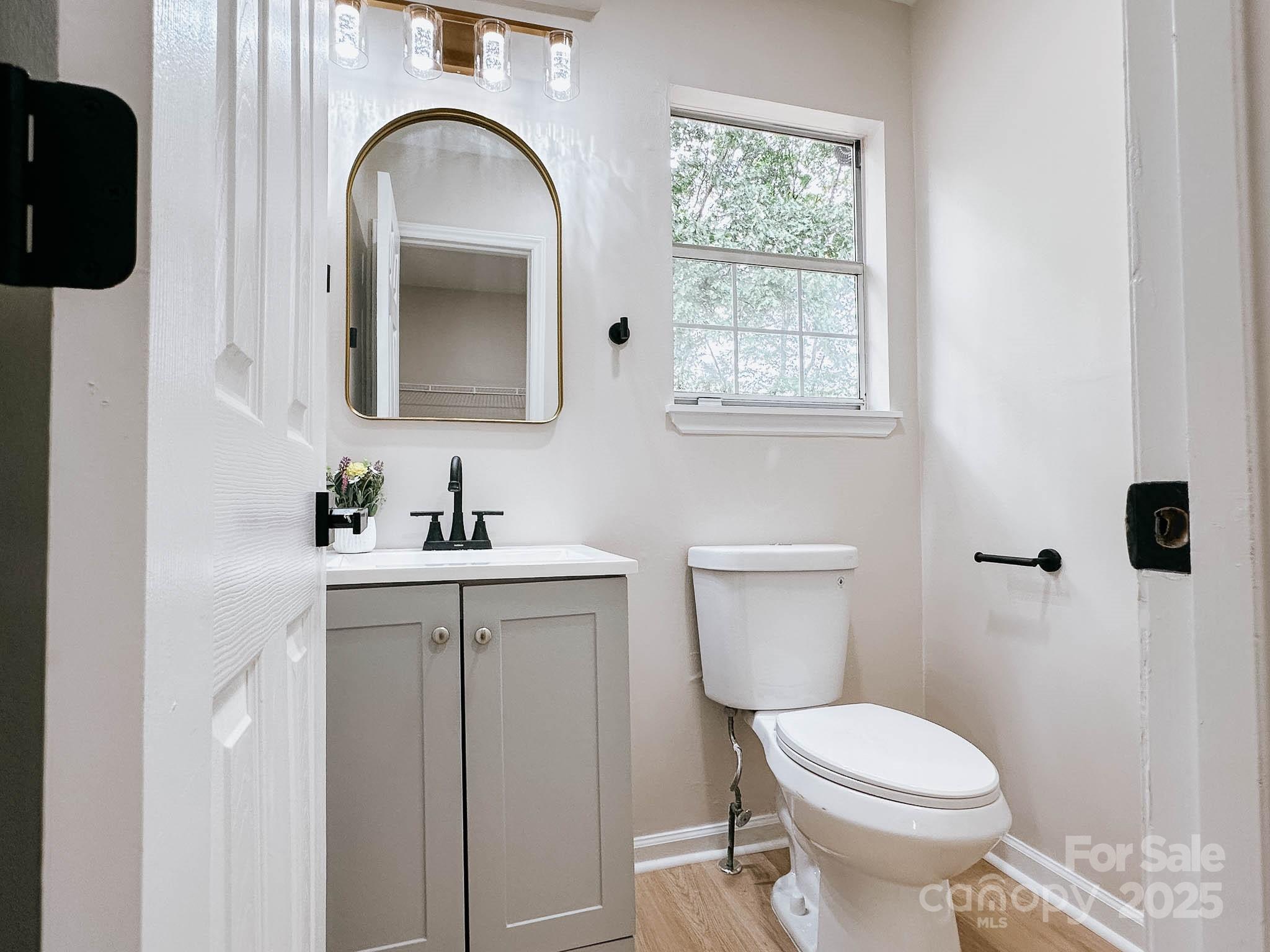 2105 Killarney Place Charlotte, NC 28262 - Photo 11 of 43 a bathroom with a toilet a sink and mirror