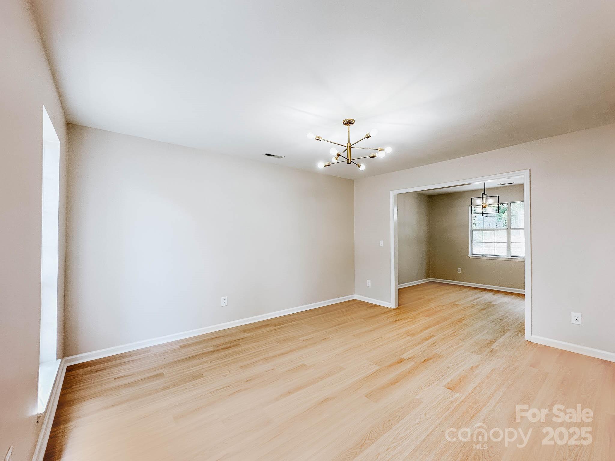 2105 Killarney Place Charlotte, NC 28262 - Photo 13 of 43 a view of an empty room with window and wooden floor