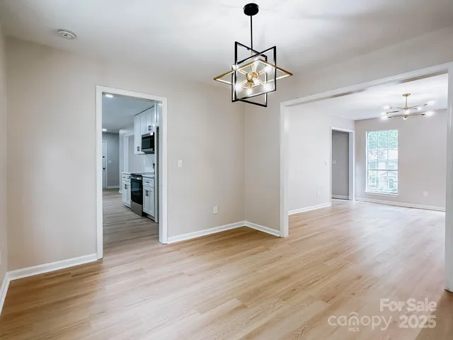 a view of a livingroom with a chandelier wooden floor and a chandelier