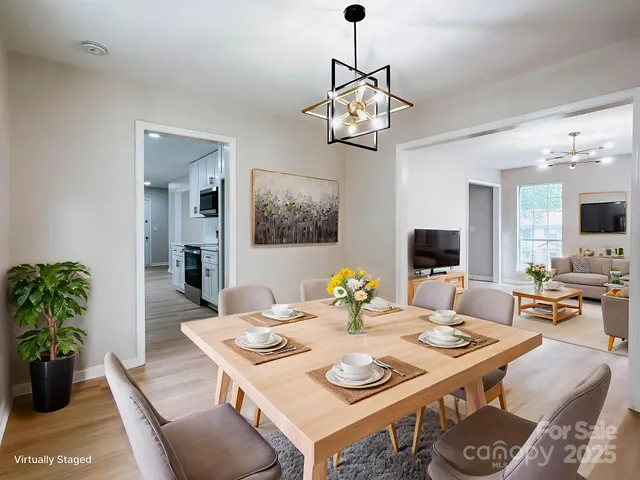 a view of a dining room with furniture a chandelier and wooden floor