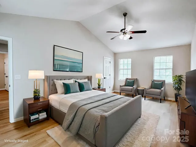 a bedroom with a bed a couch and potted plants with the outer view