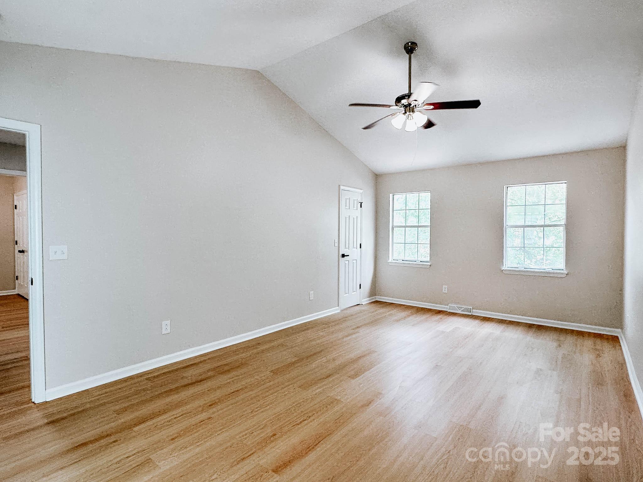 2105 Killarney Place Charlotte, NC 28262 - Photo 23 of 43 an empty room with wooden floor ceiling fan and windows