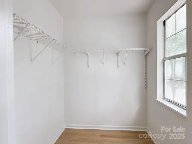 a view of a room with racks on the wall and a window