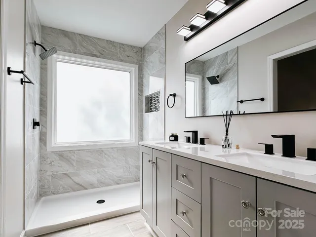 a bathroom with a shower sink and mirror