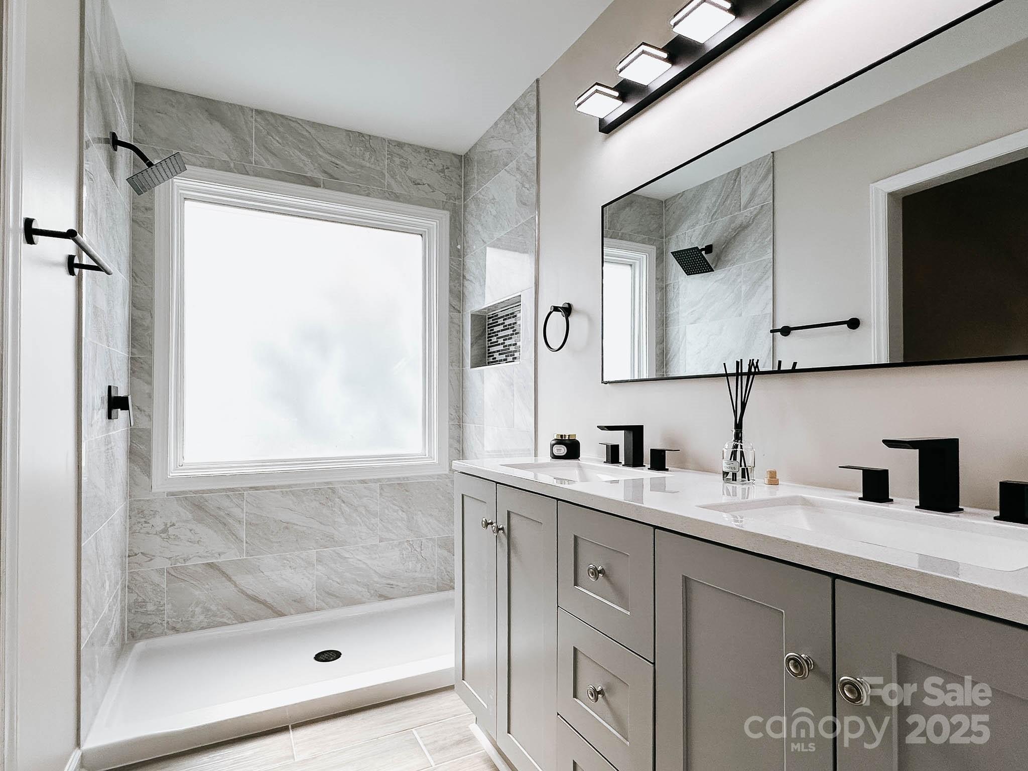 2105 Killarney Place Charlotte, NC 28262 - Photo 25 of 43 a bathroom with a shower sink and mirror