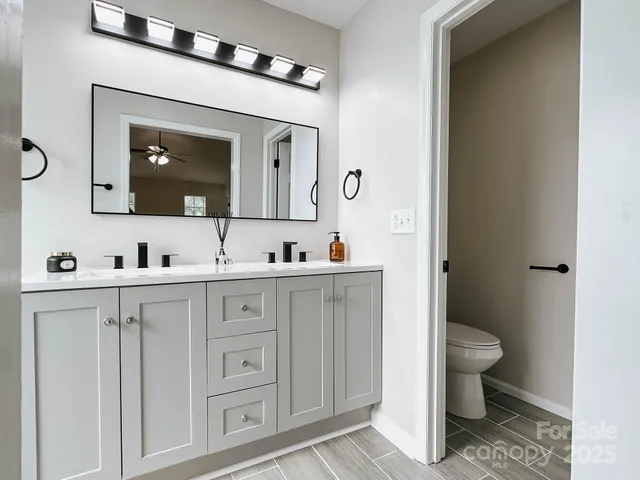 a spacious bathroom with a toilet sink and mirror