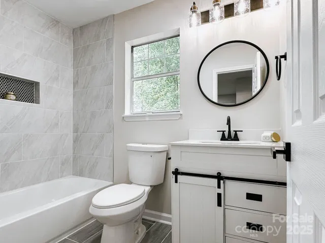 a bathroom with a sink a toilet and a mirror