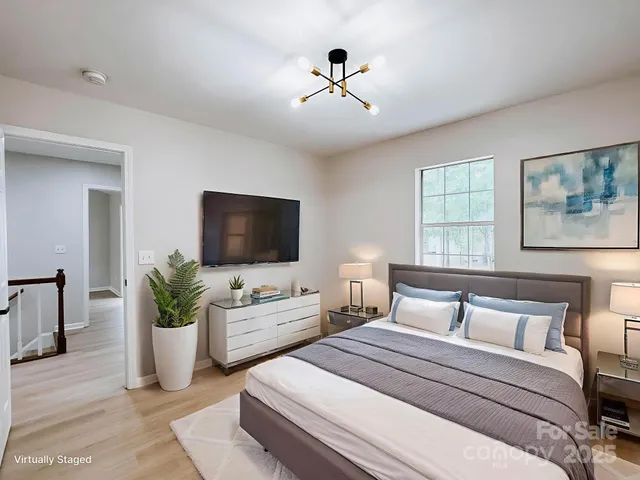 a bedroom with a bed a flat screen tv and a couch