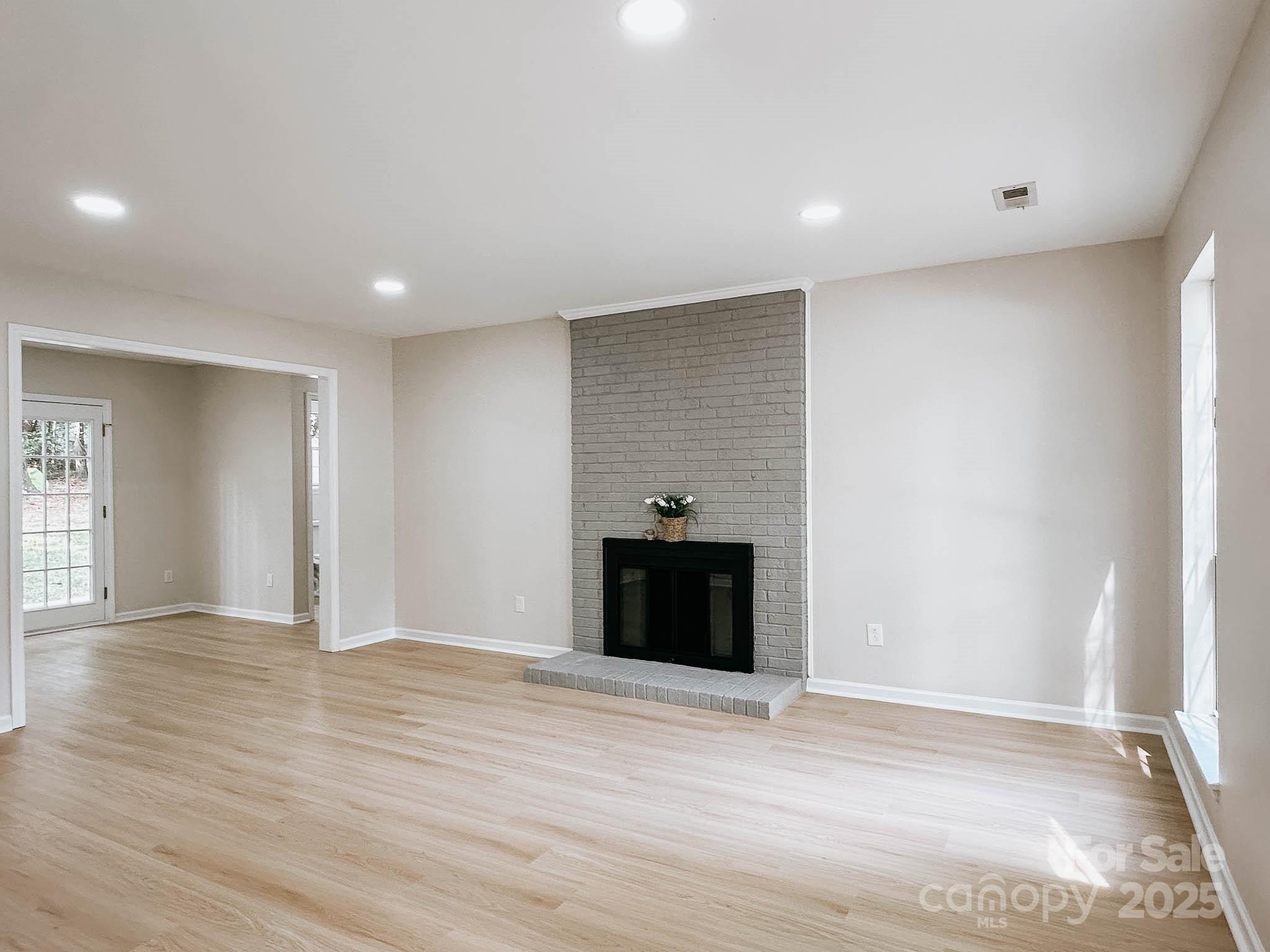 2105 Killarney Place Charlotte, NC 28262 - Photo 4 of 43 a view of an empty room with wooden floor and kitchen