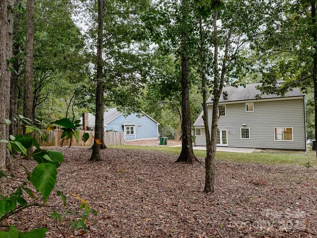 a view of a house with a yard and large tree
