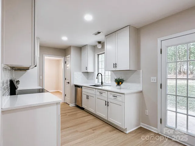 a kitchen with white cabinets and sink