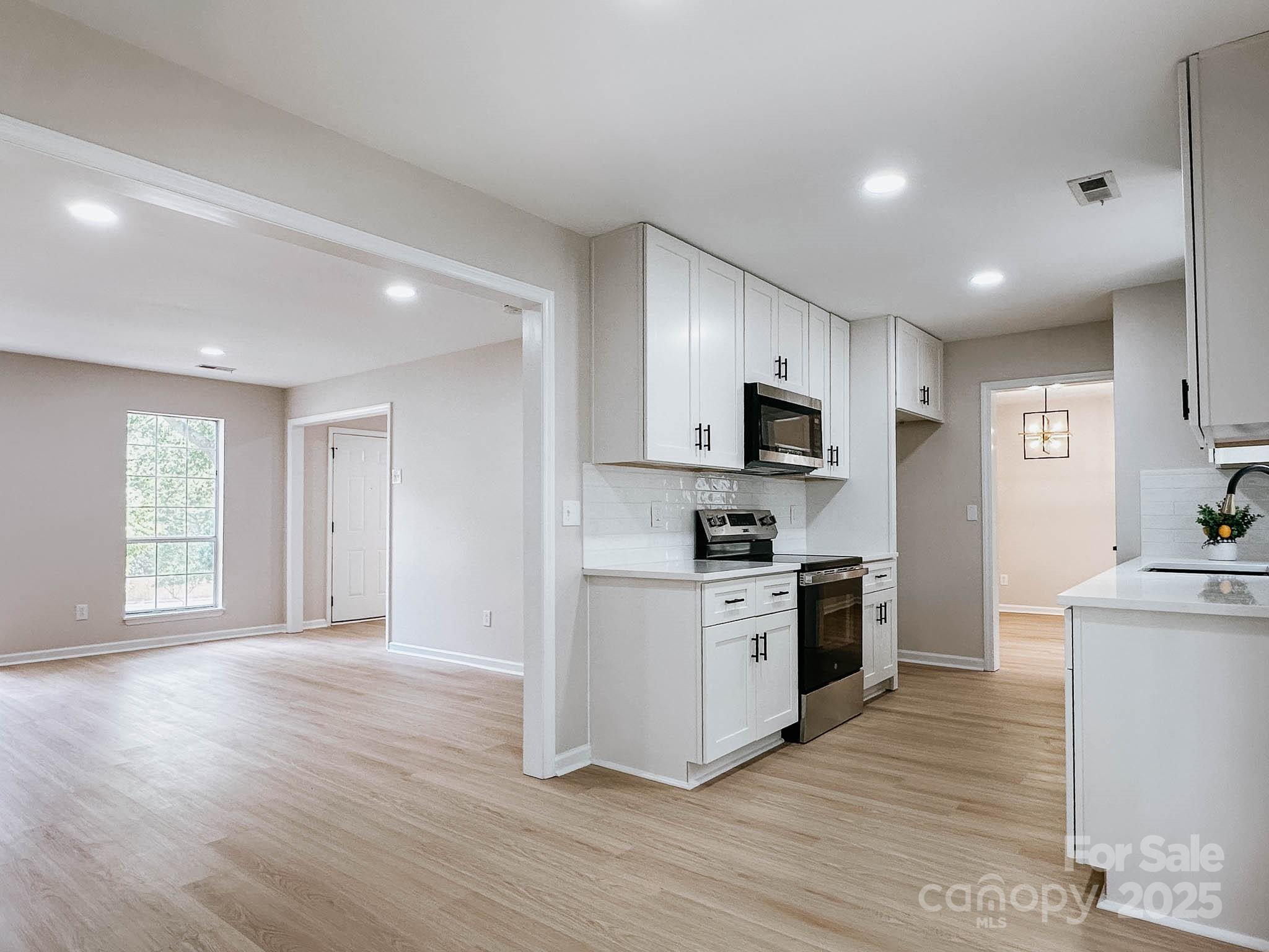 2105 Killarney Place Charlotte, NC 28262 - Photo 10 of 43 a kitchen with stainless steel appliances granite countertop a stove top oven a sink dishwasher and a refrigerator with wooden floor
