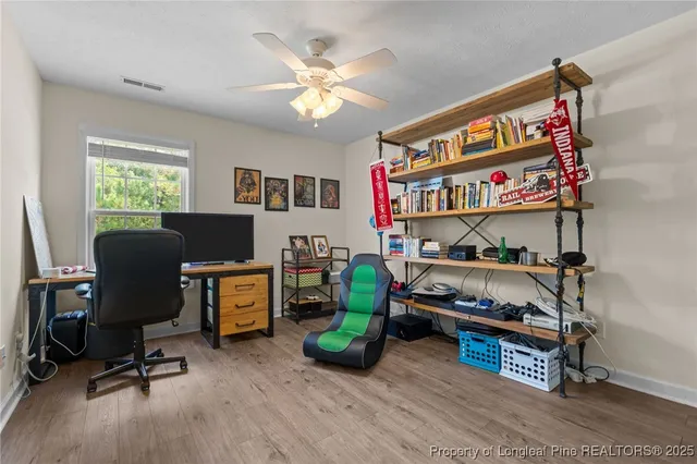 a view of a workspace with furniture and a window