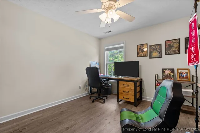 a view of a workspace with furniture and a window