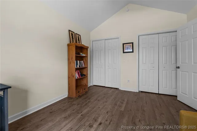 a view of an empty room with wooden floor and closet