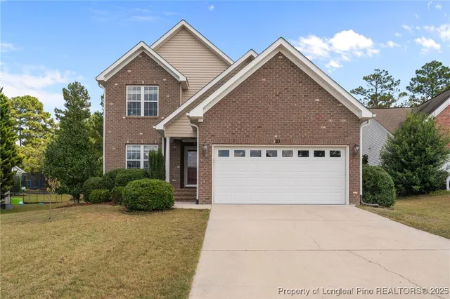 a front view of house with yard and trees in the background