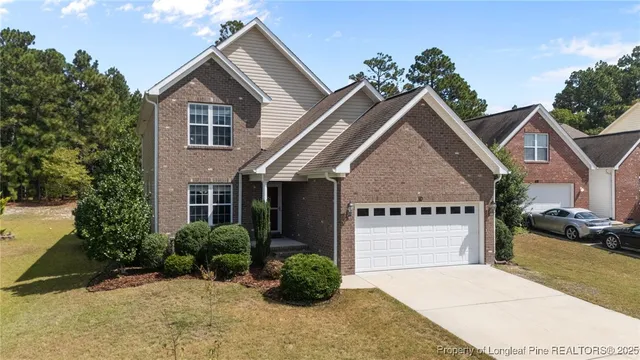 a view of a house with a yard and potted plants