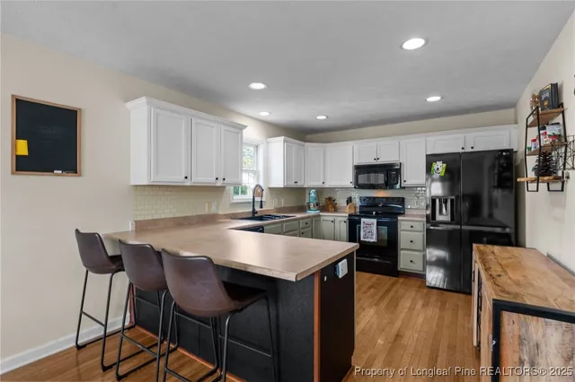 a kitchen with stainless steel appliances granite countertop a table chairs sink refrigerator and microwave