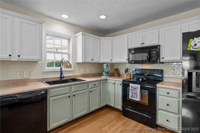 a kitchen with stainless steel appliances granite countertop white cabinets granite counter tops and a window
