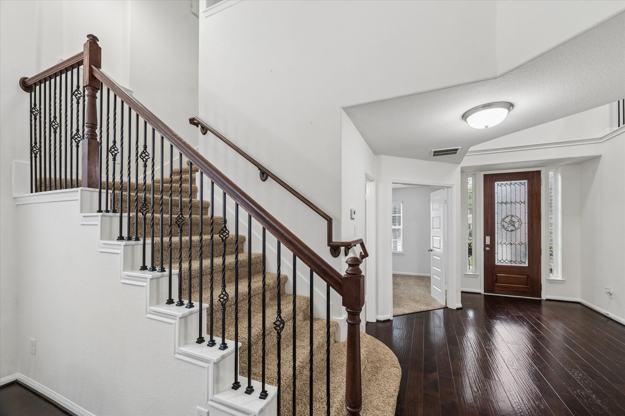 7015 Riata Hills Lane Spring, TX 77379 - Photo 2 of 33 The foyer offers a welcoming and spacious entry, showcasing the home’s versatility. Rich dark wood flooring paired with light walls creates a beautiful and harmonious contrast.