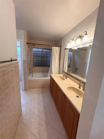 a bathroom with a tub sink and mirror