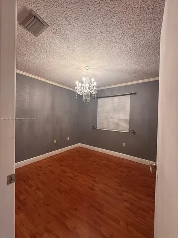 a view of wooden floor and chandelier in a room