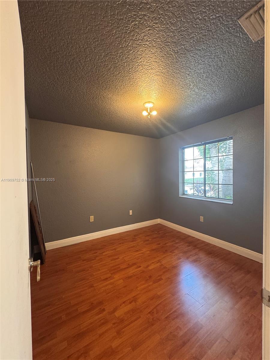 17910 Southwest 137th Court Miami, FL 33177 - Photo 17 of 25 an empty room with wooden floor and windows
