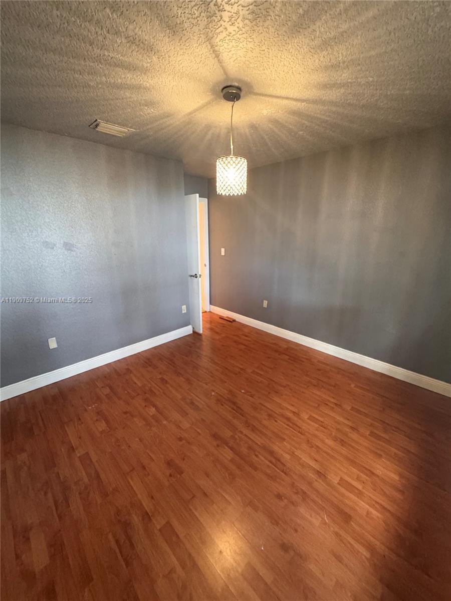 17910 Southwest 137th Court Miami, FL 33177 - Photo 20 of 25 a view of an empty room with wooden floor