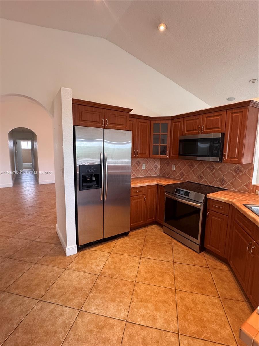 17910 Southwest 137th Court Miami, FL 33177 - Photo 6 of 25 a kitchen with stainless steel appliances granite countertop a refrigerator and a stove top oven