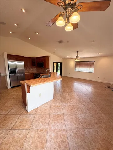 a kitchen with stainless steel appliances granite countertop a sink a stove top oven a counter space and cabinets