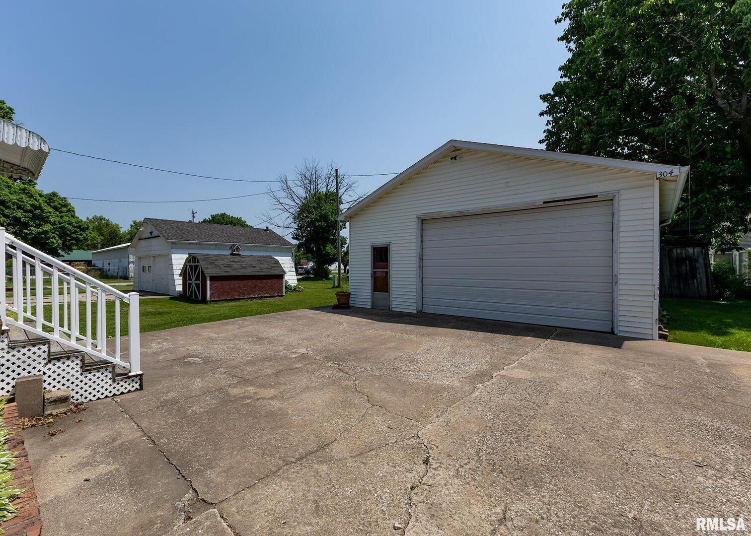 304 South 5th Avenue New Windsor, IL 61465 - Photo 2 of 29 a front view of a house with a yard and garage