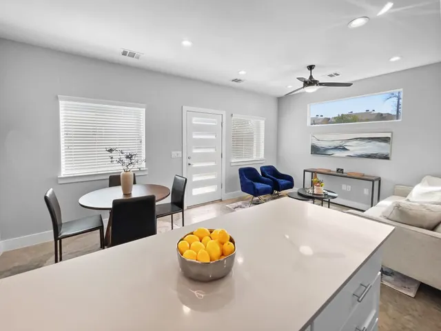 a kitchen with a dining table chairs and refrigerator