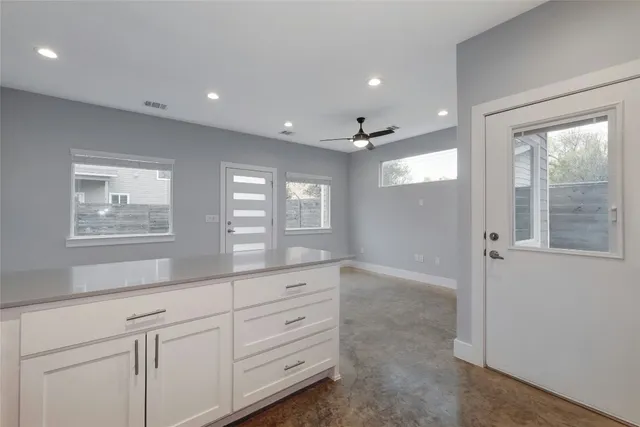 a view of a kitchen center refrigerator and windows