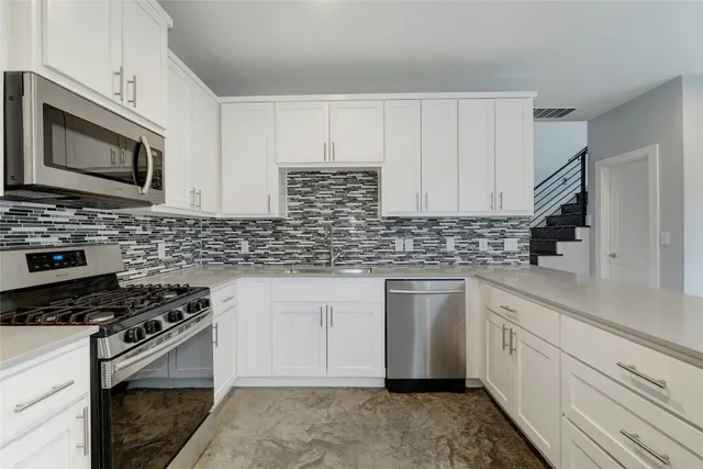 a kitchen with stainless steel appliances a sink stove and microwave