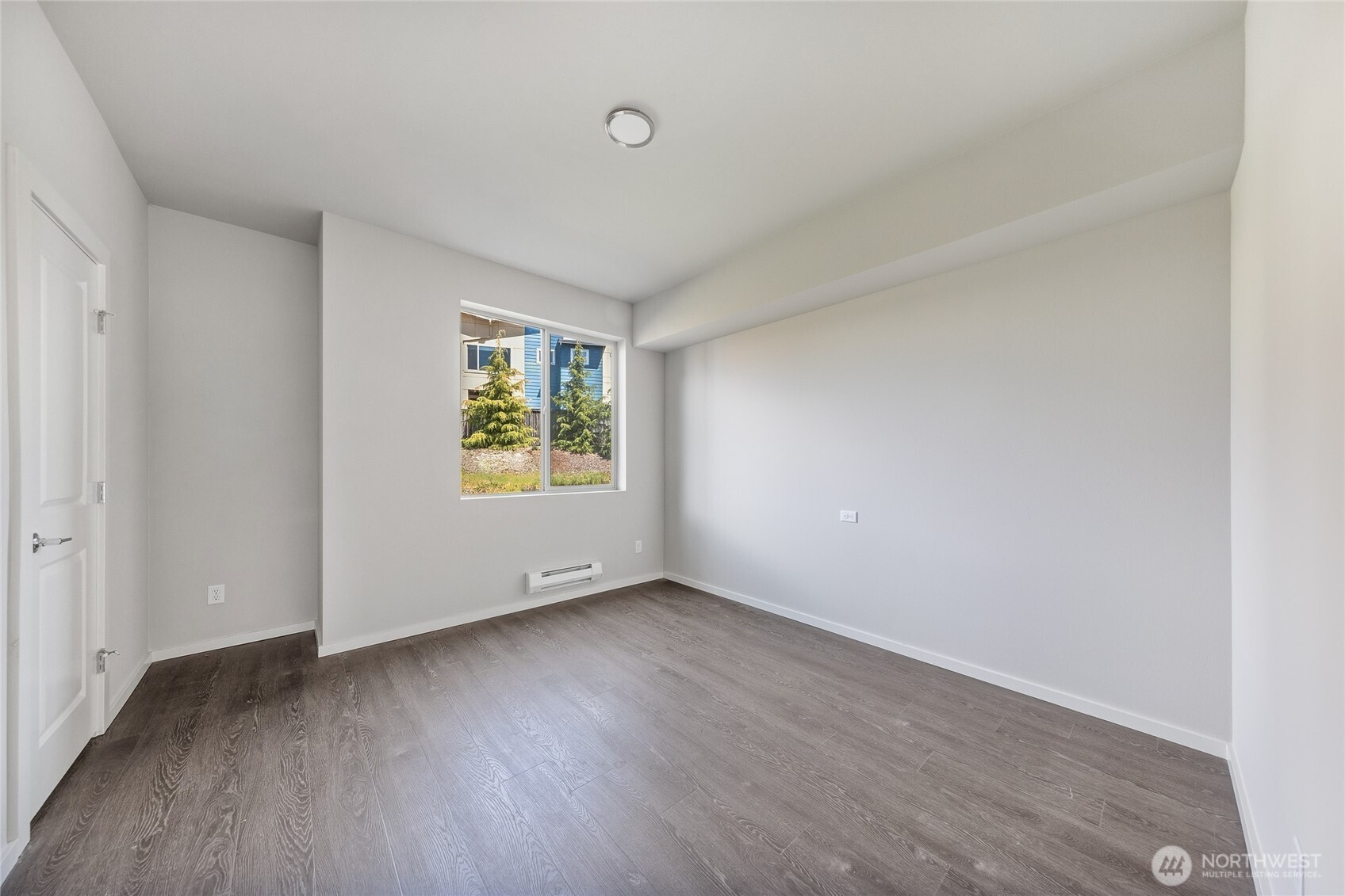 1066 Southwest 99th Place, Unit 55 Seattle, WA 98106 - Photo 19 of 21 an empty room with wooden floor and windows