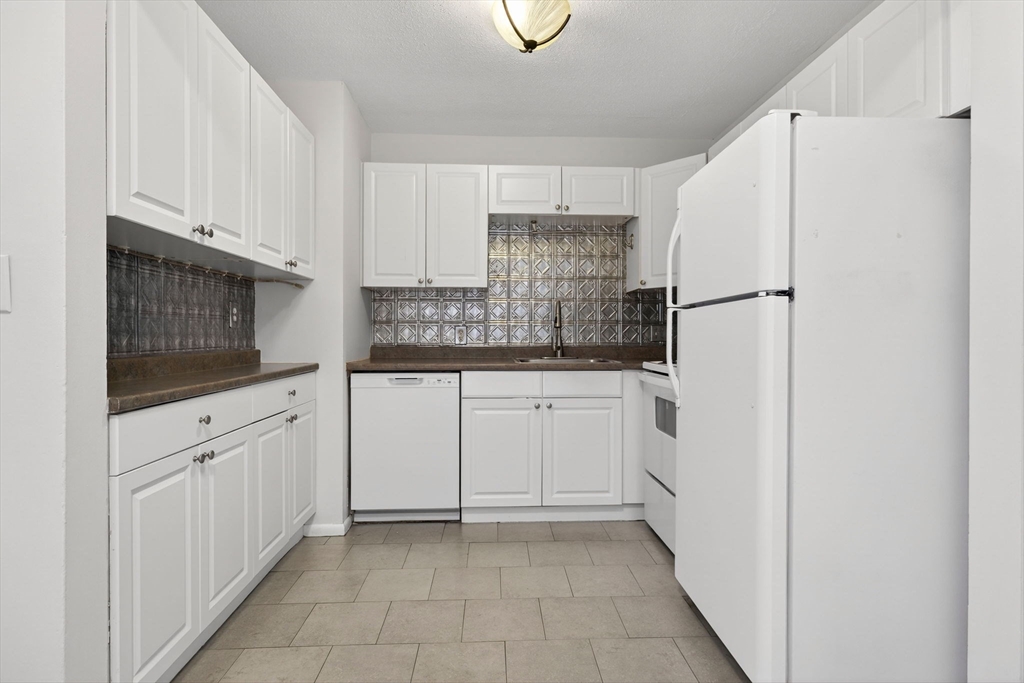 8 Kittredge Street, Unit 10 Boston, MA 02131 - Photo 2 of 16 a kitchen with white cabinets and white appliances