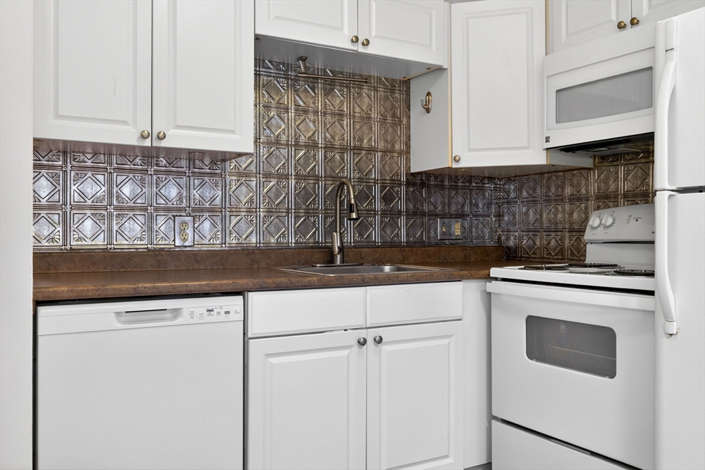 8 Kittredge Street, Unit 10 Boston, MA 02131 - Photo 3 of 16 a kitchen with granite countertop white cabinets and white appliances