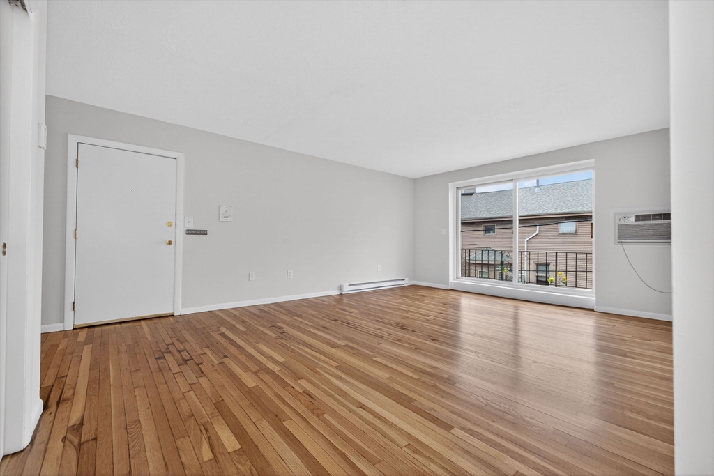 8 Kittredge Street, Unit 10 Boston, MA 02131 - Photo 10 of 16 a view of an empty room with wooden floor and a window