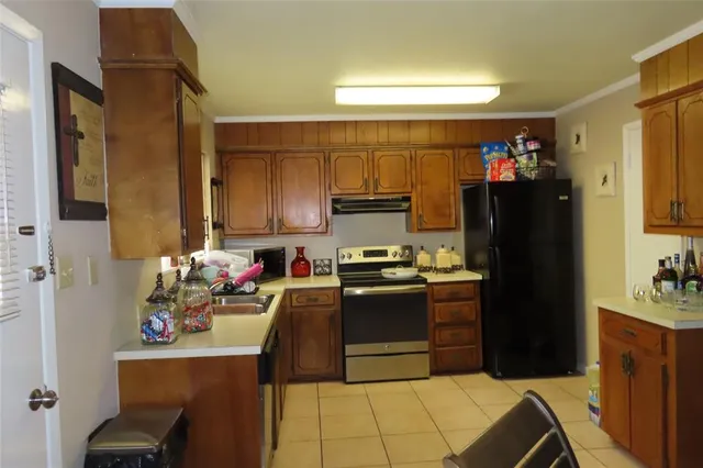 a kitchen with stainless steel appliances granite countertop a refrigerator stove and sink