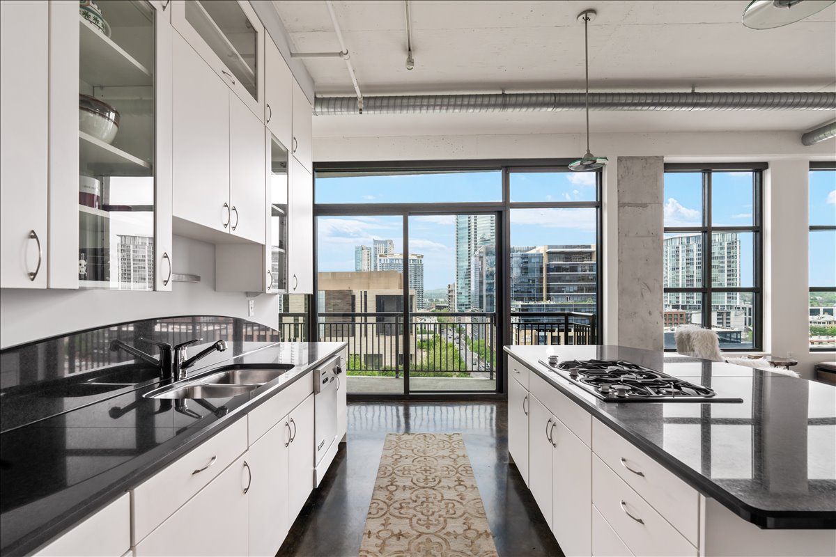 311 West 5th Street, Unit 1005 Austin, TX 78701 - Photo 10 of 30 The open kitchen captures sweeping city views and welcomes abundant natural light, creating a bright, sophisticated flow into the living space